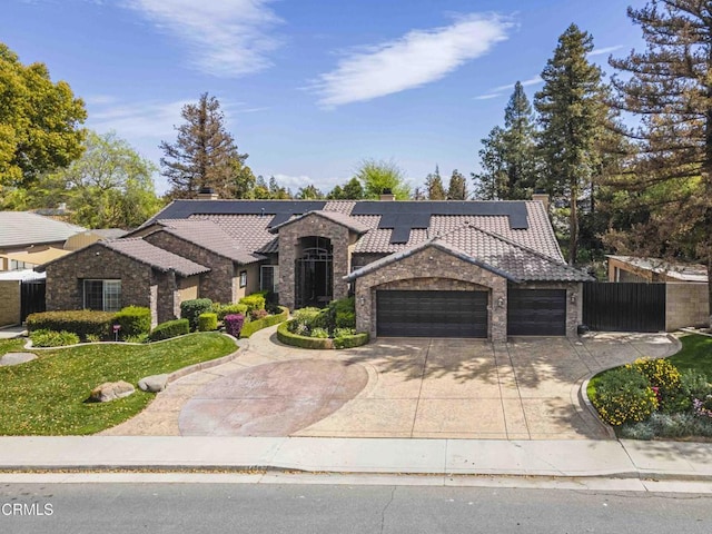 view of front facade featuring solar panels, fence, a chimney, driveway, and an attached garage