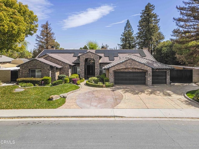 view of front of house featuring a front lawn, concrete driveway, a garage, stone siding, and a tiled roof