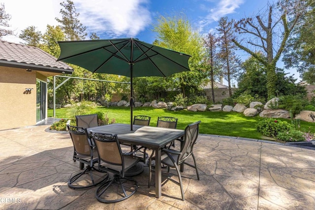 view of patio with outdoor dining space and fence