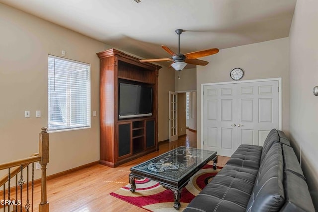 living room with baseboards, light wood-style floors, and ceiling fan