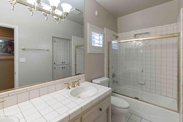 bathroom with tile patterned floors, combined bath / shower with glass door, toilet, and vanity