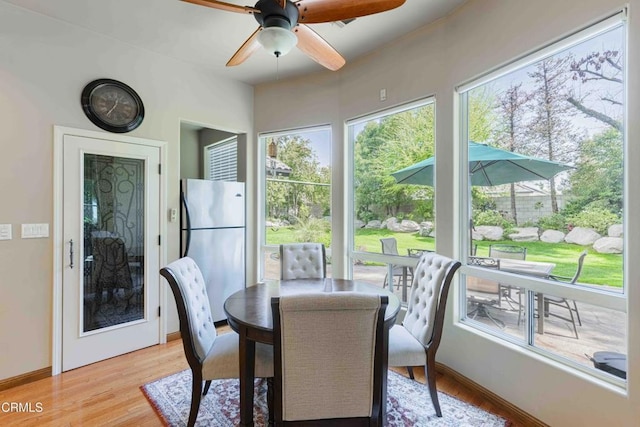 dining area with light wood-type flooring, baseboards, and ceiling fan