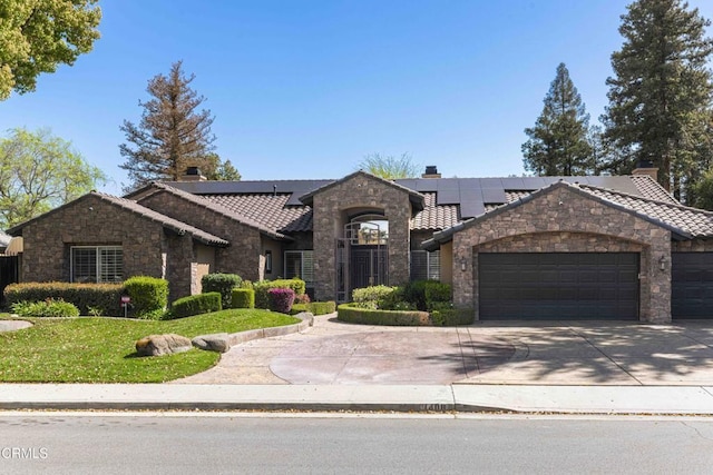 view of front of home with solar panels, an attached garage, stone siding, and a chimney