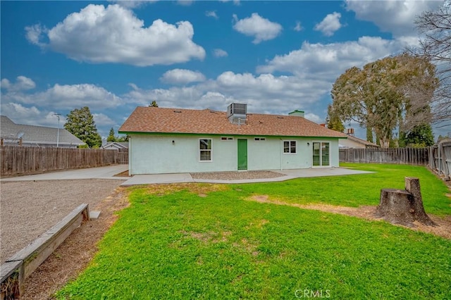 rear view of house featuring stucco siding, a patio, a yard, and a fenced backyard