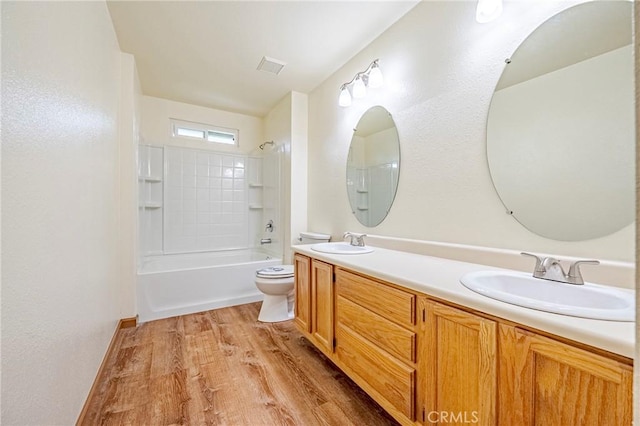 full bathroom featuring double vanity, toilet, wood finished floors, and a sink