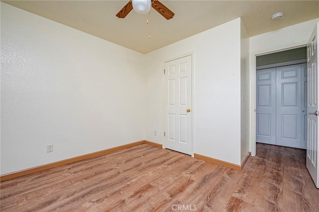 unfurnished bedroom with a ceiling fan, baseboards, and light wood-type flooring