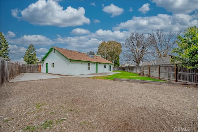 back of property with cooling unit, a yard, a fenced backyard, and a patio area