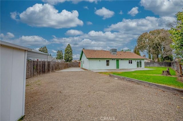 rear view of property with a patio, a lawn, and a fenced backyard