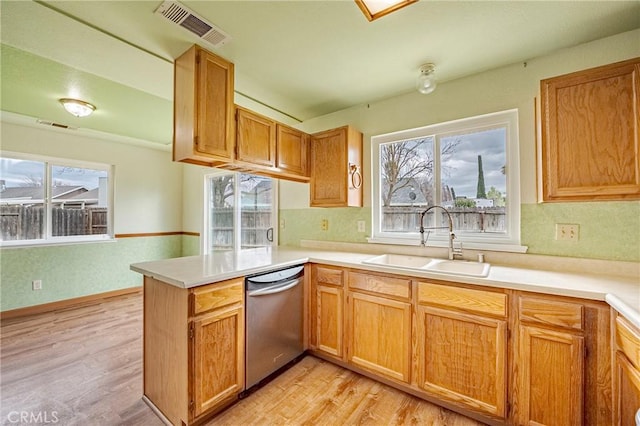 kitchen with visible vents, a wealth of natural light, a peninsula, stainless steel dishwasher, and a sink