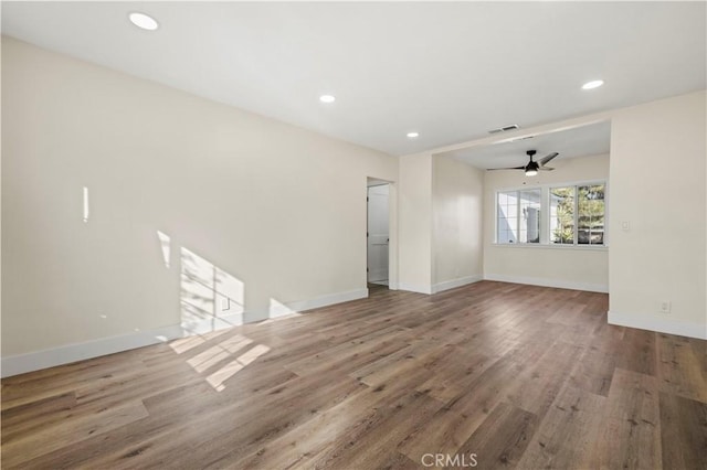 unfurnished room featuring baseboards, a ceiling fan, and wood finished floors