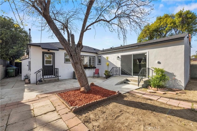 rear view of property featuring a patio area and stucco siding