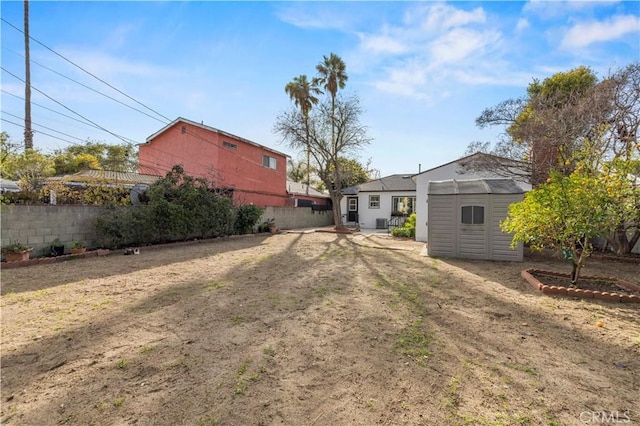 view of yard featuring an outbuilding, a storage unit, and a fenced backyard