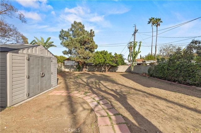 view of yard with an outbuilding, a storage shed, and a fenced backyard