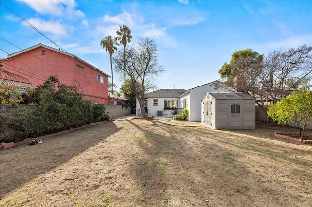 back of property featuring an outbuilding, a storage unit, and a fenced backyard