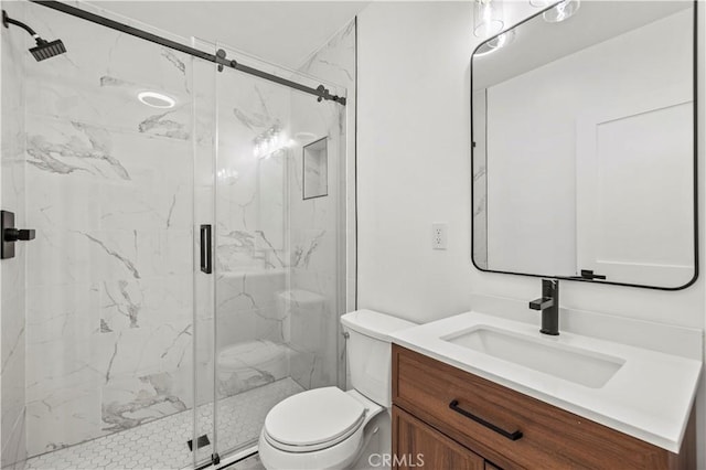 bathroom featuring a marble finish shower, toilet, and vanity