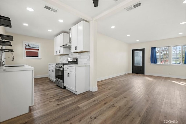 kitchen featuring a sink, visible vents, stainless steel gas stove, and backsplash