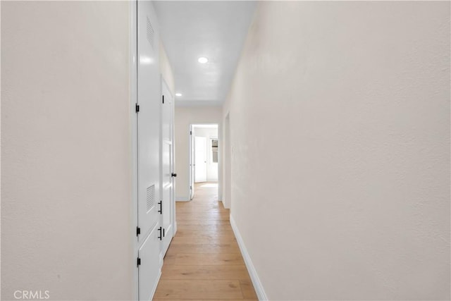 hallway featuring recessed lighting, light wood-style floors, and baseboards