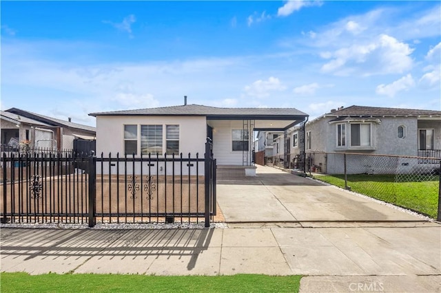 view of front of house featuring an attached carport, a residential view, driveway, and a fenced front yard