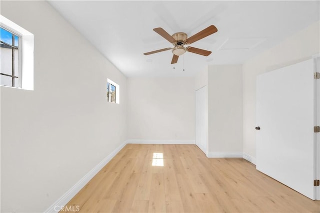 empty room with light wood finished floors, baseboards, and ceiling fan