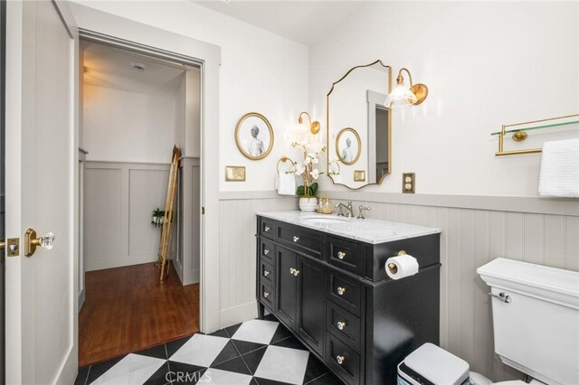 274 Grand Ave, Long Beach, CA 90803 - bathroom featuring wainscoting, toilet, vanity, and a decorative wall