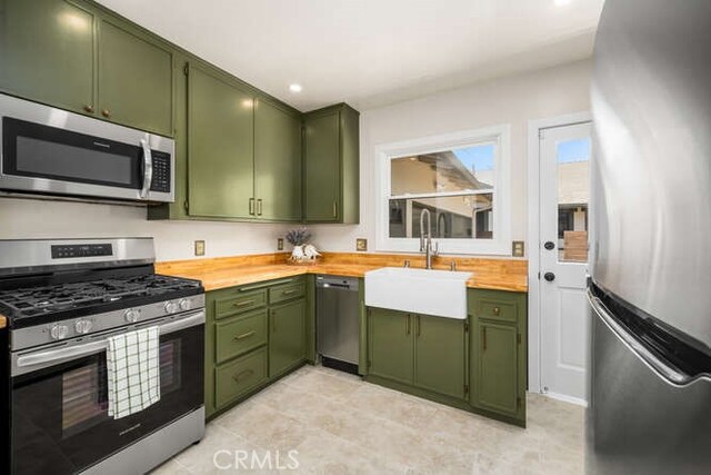 274 Grand Ave, Long Beach, CA 90803 - kitchen with green cabinets, appliances with stainless steel finishes, a sink, butcher block countertops, and recessed lighting