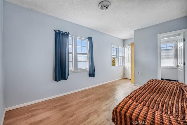 6324 Denver Ave, Los Angeles, CA 90044 - unfurnished bedroom with baseboards, a textured ceiling, and wood finished floors