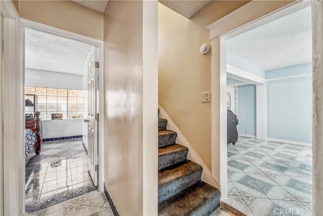 6324 Denver Ave, Los Angeles, CA 90044 - staircase with a textured ceiling, baseboards, and tile patterned floors