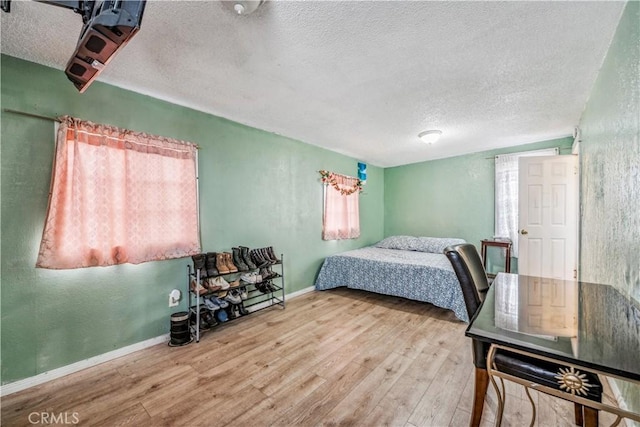 6324 Denver Ave, Los Angeles, CA 90044 - bedroom featuring baseboards, a textured ceiling, and wood finished floors