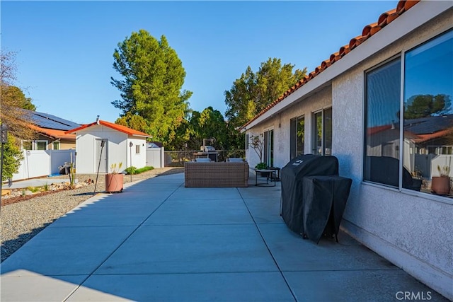 view of patio / terrace featuring an outbuilding, a fenced backyard, a shed, and grilling area