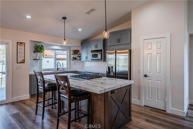 kitchen with visible vents, a sink, open shelves, stainless steel appliances, and vaulted ceiling