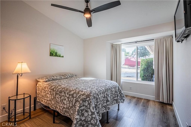 bedroom featuring ceiling fan, baseboards, lofted ceiling, and wood finished floors