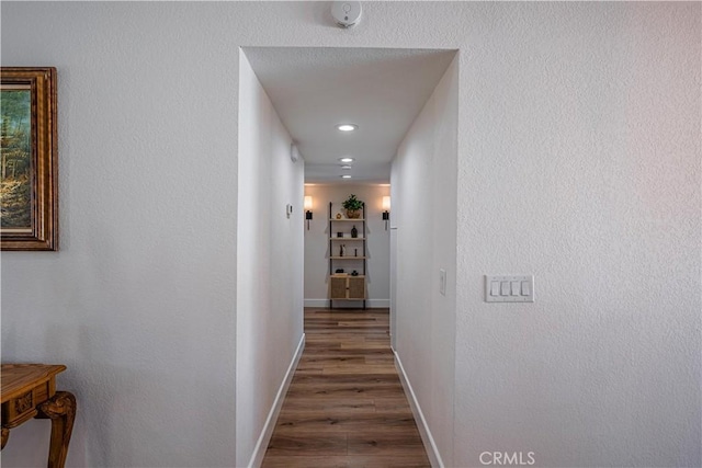 hall featuring baseboards and wood finished floors