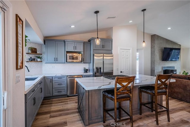 kitchen featuring visible vents, gray cabinetry, open shelves, appliances with stainless steel finishes, and lofted ceiling