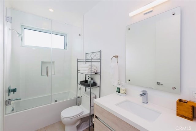 bathroom featuring toilet, vanity, and bath / shower combo with glass door