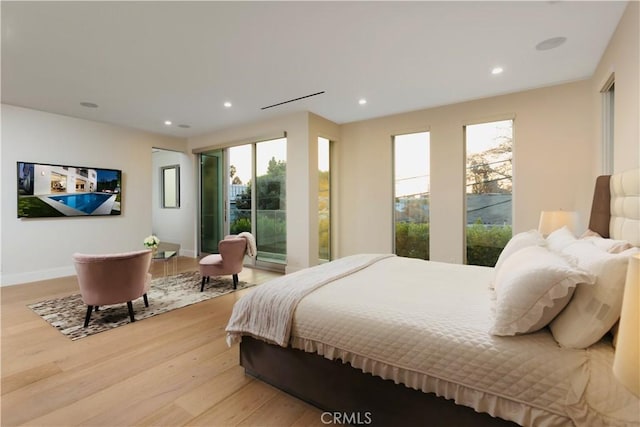 bedroom with recessed lighting, multiple windows, light wood-style flooring, and baseboards