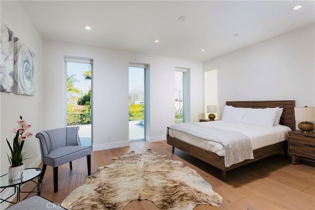 bedroom with access to exterior, light wood-style flooring, recessed lighting, and baseboards