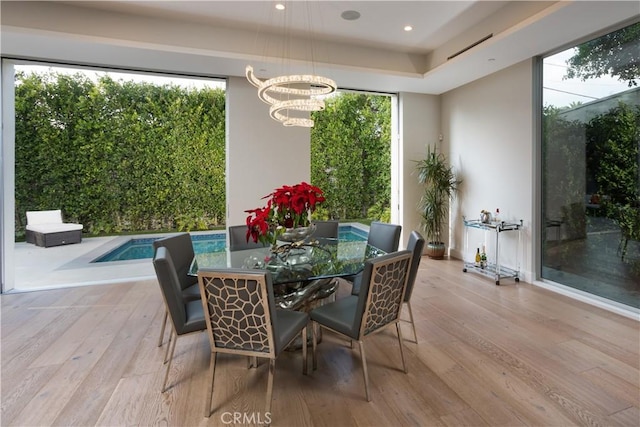 dining room with a chandelier, recessed lighting, and light wood-type flooring