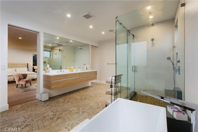 ensuite bathroom featuring recessed lighting, a stall shower, ensuite bathroom, and double vanity