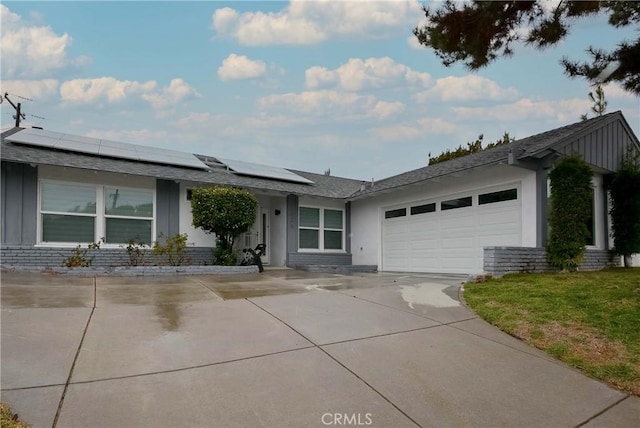 single story home featuring board and batten siding, concrete driveway, a garage, and a front lawn