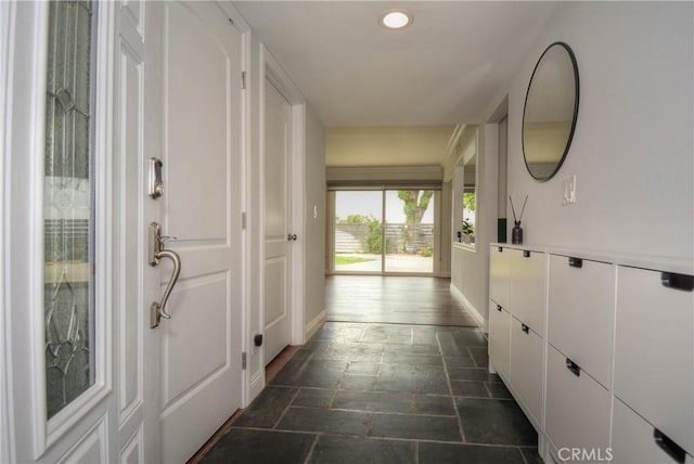 hall featuring baseboards, recessed lighting, and stone tile flooring