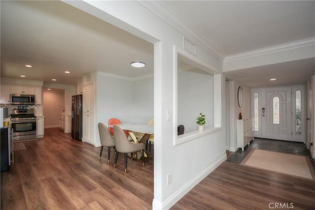 entryway with dark wood-style floors, recessed lighting, crown molding, and baseboards