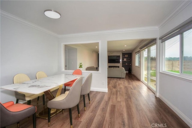 dining area with baseboards, ornamental molding, and wood finished floors
