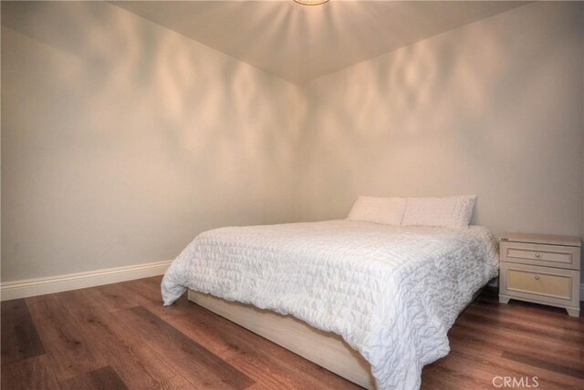 bedroom with dark wood-style floors and baseboards