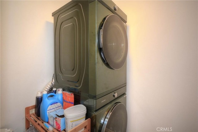 washroom with stacked washing maching and dryer and laundry area