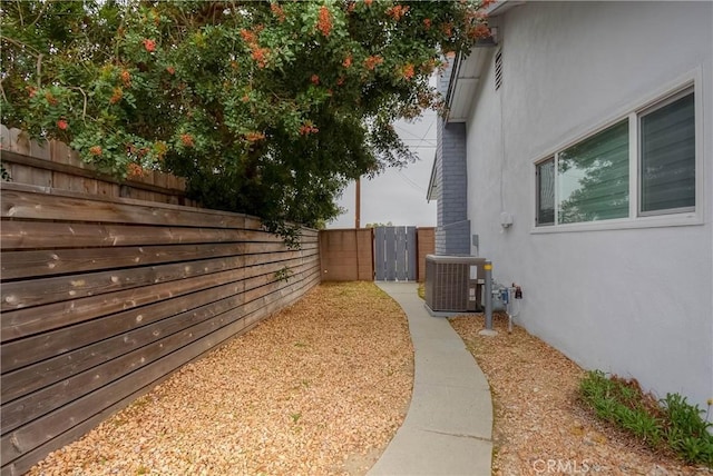view of home's exterior featuring a fenced backyard, stucco siding, and central air condition unit