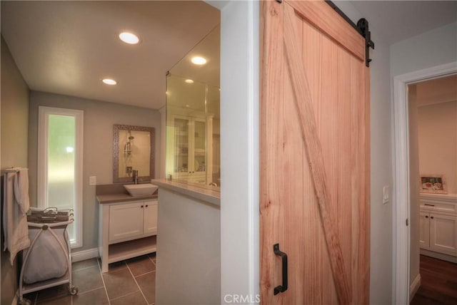 bathroom featuring baseboards, tile patterned flooring, recessed lighting, and vanity