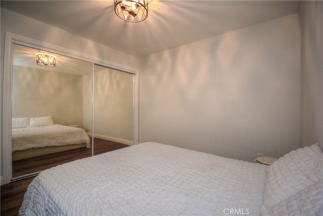 bedroom with dark wood-type flooring and a closet