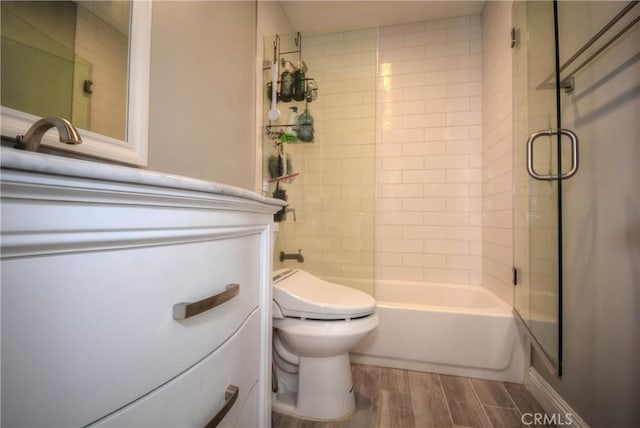 full bath with  shower combination, wood finished floors, toilet, and vanity