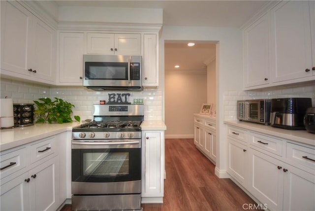 kitchen with light countertops, dark wood-style flooring, stainless steel appliances, and white cabinets