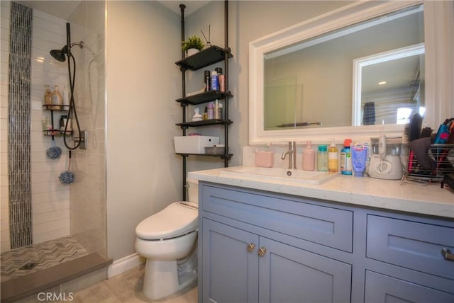 bathroom featuring toilet, vanity, and tiled shower